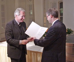 Staatssekret&auml;r Josef Lange &uuml;bergibt HAWK-Professor Dr. Wolfgang Vi&ouml;l den mit 30.000 E